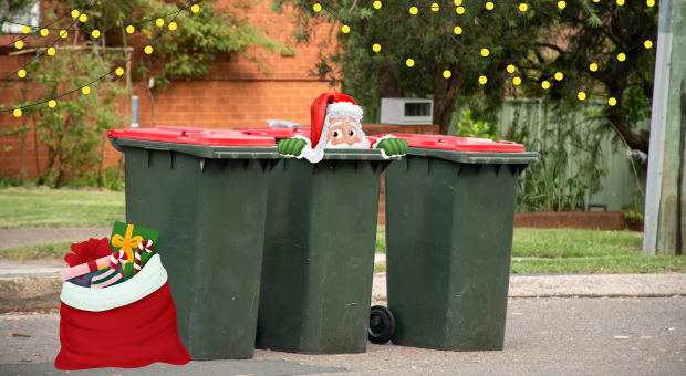 Santa peeps out of a rubbish bin